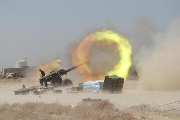 An Iraqi Shi'ite fighter fires artillery during clashes with Islamic State militants near Falluja